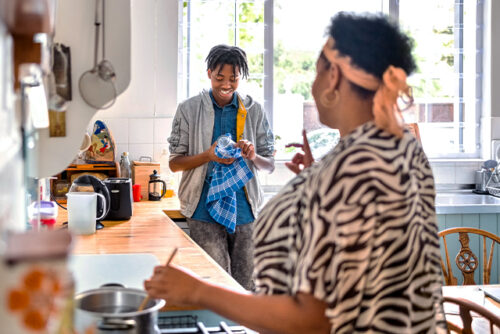 Mother and teen stand in kitchen talking