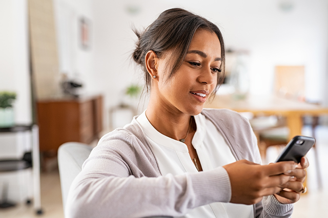 Women looks at her phone while seated