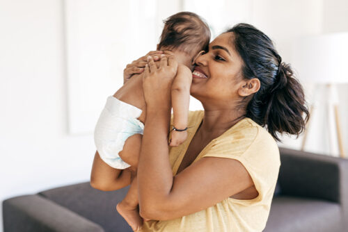 women lifts up baby to her face