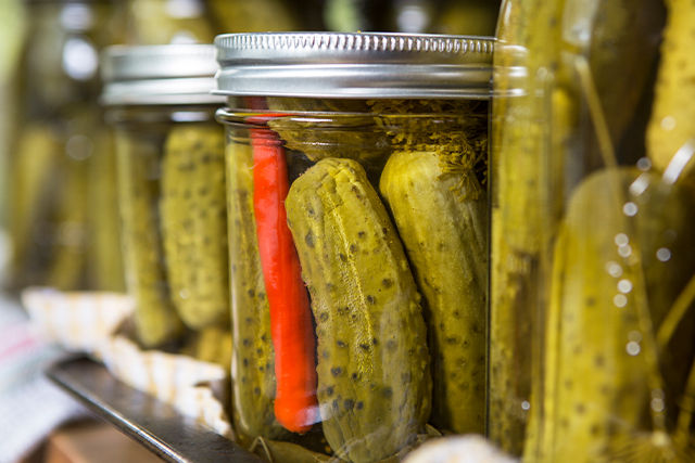 Several jars of pickles on a shelf