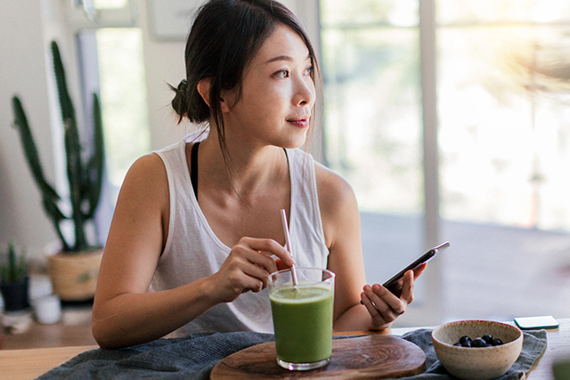 Woman drinks green smoothie