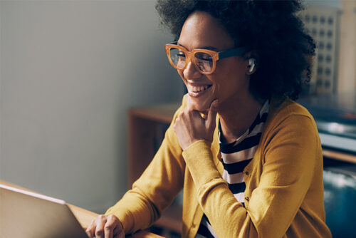 woman looking at laptop and smiling