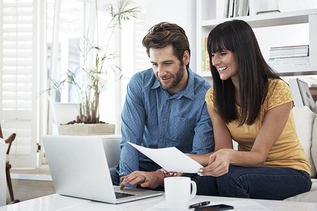 A man and a woman sit at a computer