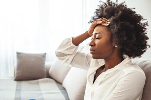 woman holds her head in her hand