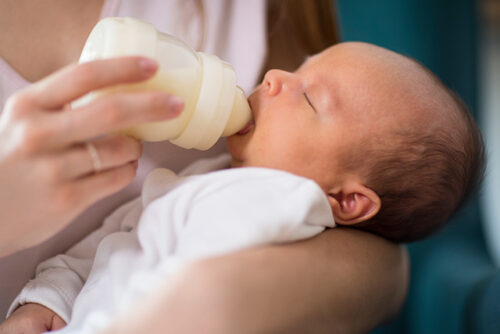 A baby is fed from a bottle
