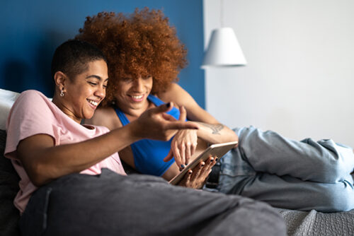Couple in bed looks at phone together