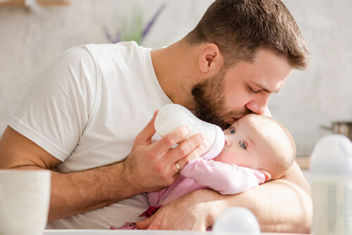 Father feeds baby from a bottle
