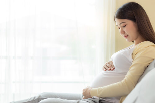 Pregnant woman holds her bump