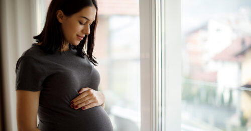 Pregnant mom holds her baby bump