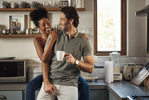 Man and woman look at each other in the kitchen