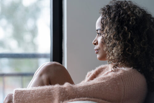 Woman turned away from the camera looks out window