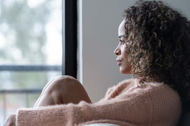 Woman turned away from the camera looks out window