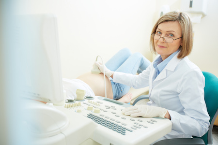 female doctor performing amniocentesis on pregnant woman