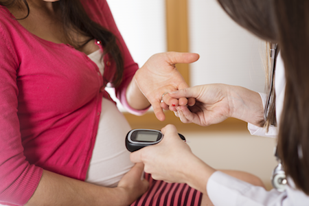 pregnant woman getting her insulin tested by a doctor