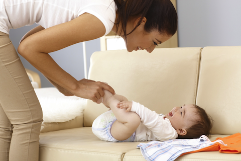 mother playing with a baby with a full head of hair
