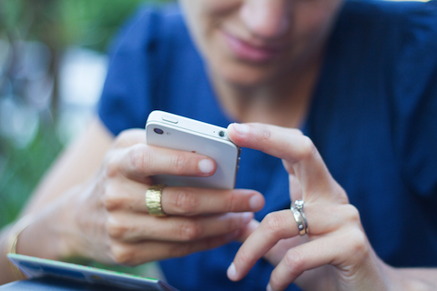 pregnant woman looking at her white iPhone