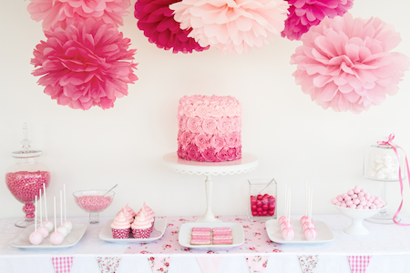 pink and white baby shower display table with desserts and flowers