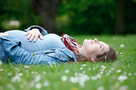 relaxed pregnant woman lying on the grass