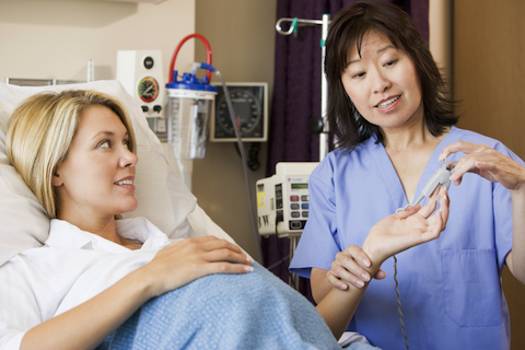 nursing giving woman in delivery room an epidural