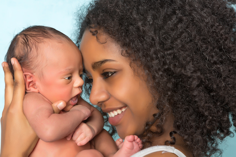happy woman holding newborn baby
