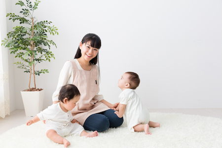 woman sitting on a furry carpet with her twin babies