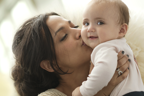 mom kissing her baby