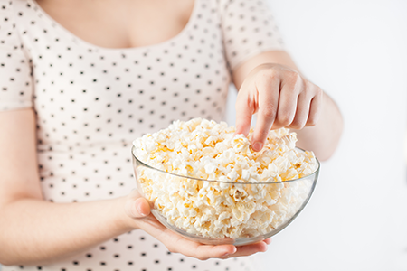 pregnant woman eating popcorn