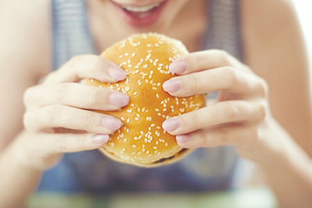 pregnant woman eating a cheeseburger