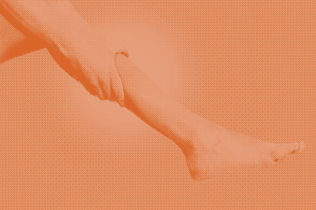 faded image of a pregnant woman holding her leg